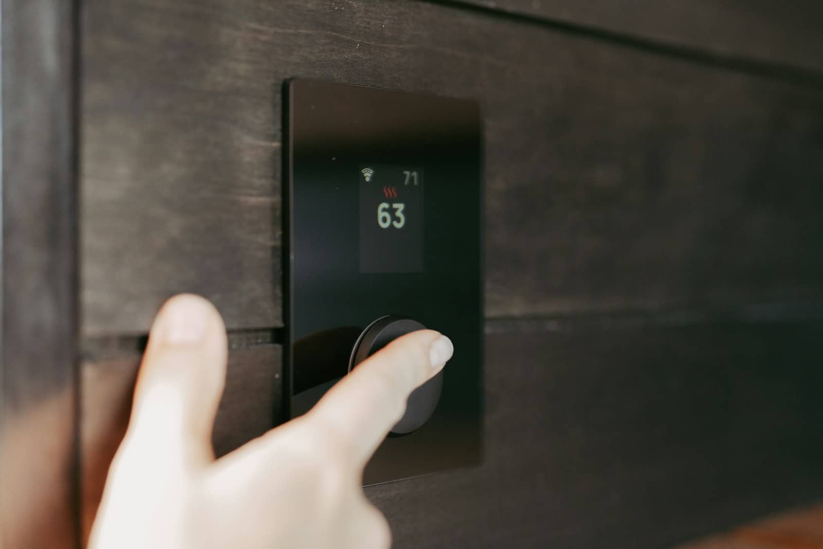 Thermostat control being adjusted during a home energy audit